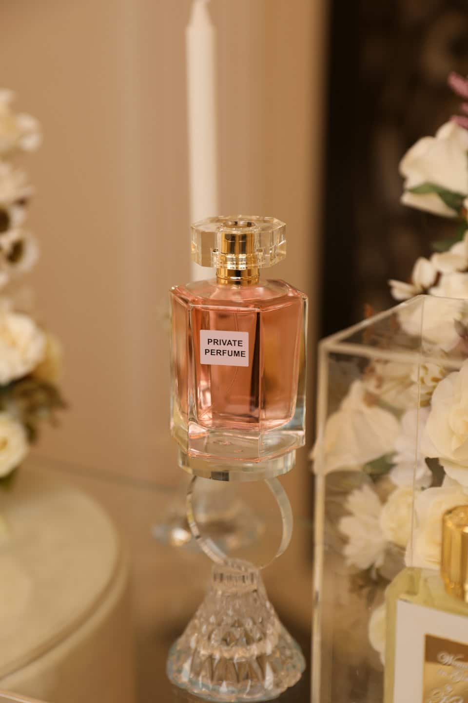 Sechseckige Parfümflasche mit roségoldener Flüssigkeit auf einem Ständer.